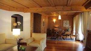 un soggiorno con divano e tavolo di Hotel Bellevue Suites & Spa a Cortina dʼAmpezzo