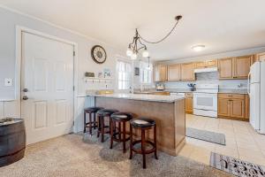 a kitchen with wooden cabinets and a counter with bar stools at Downtown Beauty - Unit 1 in Conway