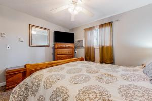 a bedroom with a bed and a dresser and a television at Downtown Beauty - Unit 1 in Conway