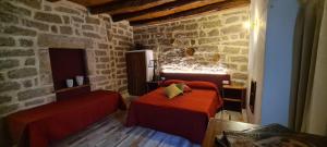 a bedroom with two beds and a stone wall at Kabula in Olbia