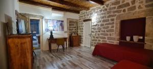 a bedroom with a red bed and a stone wall at Kabula in Olbia