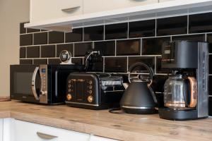 a kitchen counter with a toaster oven and a microwave at Wonderful Townhouse with BBQ Backyard in Great Yarmouth