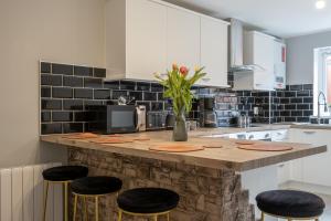 a kitchen with a counter top with stools at Wonderful Townhouse with BBQ Backyard in Great Yarmouth