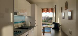 een keuken met een wastafel en een raam met uitzicht bij MIOUGRANO 2 Pieces Climatise 47m2 Piscine, Parking in Fréjus