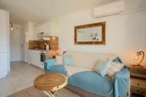 a living room with a blue couch and a table at Studio Golfe de Saint Tropez in Cavalaire-sur-Mer