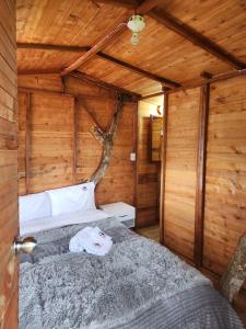 a bedroom with a bed in a wooden cabin at Villa Mimosa Finca Hotel in Quimbaya