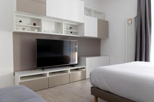 a bedroom with a flat screen tv on a white cabinet at Myro's House in La Spezia