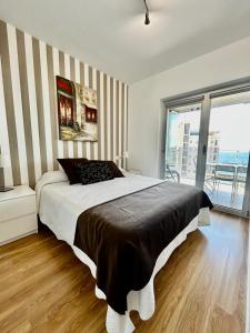a bedroom with a large bed with a striped wall at Mirador de Calpe. Apartment with panoramic views. in Calpe