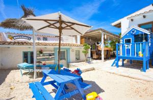 a patio with a blue picnic table and an umbrella at Villa in Llucmajor with Sea View and Private Pool in Llucmajor