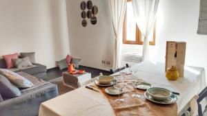 a living room with a table and a couch at House with Dream Panoramic Terrace in the Heart of Bosa, 80 sqm with BBQ and Breathtaking View in Bosa