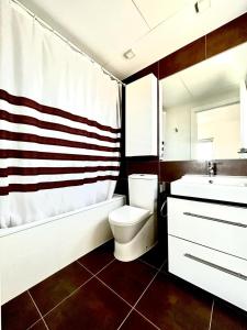 a bathroom with a toilet and a tub and a sink at Mirador de Calpe. Apartment with panoramic views. in Calpe