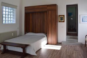 a bedroom with a bed with a wooden headboard at Open space Villa Miani in Silea