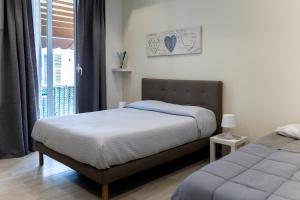 a bedroom with two beds and a window with a balcony at Myro's House in La Spezia