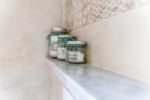 a shelf with jars on it in a bathroom at Myro's House in La Spezia +37 photos
