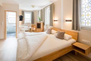 a bedroom with a large bed with white sheets and pillows at Landhotel Löwen in Erlabrunn