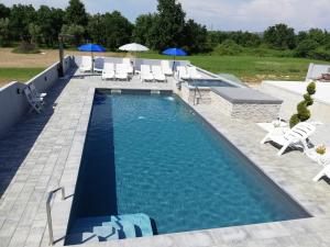a large swimming pool with chairs and umbrellas at Apartment Camelia in Poreč