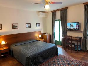 a bedroom with a bed and a flat screen tv at Casa Violetta B&B in Agrate Conturbia