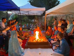 a group of people sitting around a fire at OM Yoga center in Slovenska Bistrica