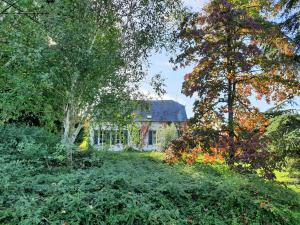 a house in the middle of a yard with trees at Le Cèdre 