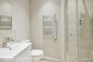 a bathroom with a shower and a toilet and a sink at Superb New Build 2 Bed Flat - 6 Ophelia Court in Epsom
