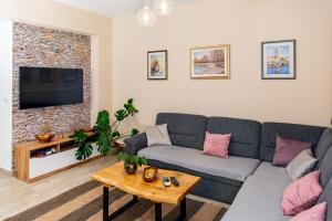 a living room with a couch and a tv at Calypso - newly equiped, with separate entrance and parking in Supetar