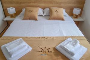 1 dormitorio con 1 cama con toallas en DM Apartments, en Kotor