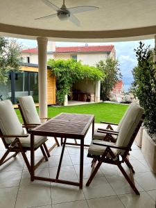 a patio with a wooden table and two chairs at Villa Romana III Omis in Omiš