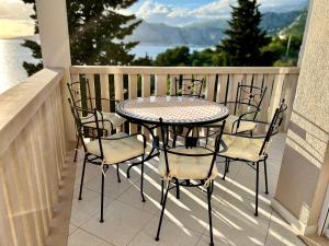 een tafel en stoelen op een balkon met uitzicht op het water bij Villa Romana III Omis in Omiš