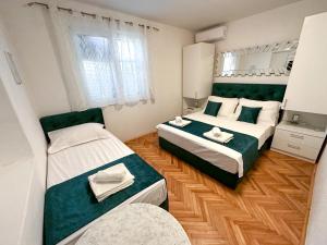 1 dormitorio con 2 camas y espejo en Apartmani Daša Tučepi, en Tučepi
