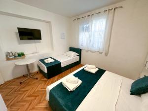 a small room with two beds and a tv at Apartmani Daša Tučepi in Tučepi