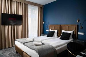 una camera da letto con un grande letto con pareti blu di 4Wings Apartments a Cracovia