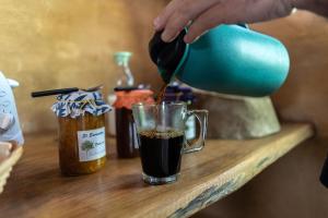 a person pouring coffee into a cup on a table at Hostel Al Infinito in San Javier