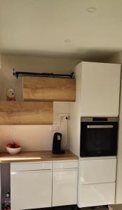 eine Küche mit weißen Schränken und einer Mikrowelle in der Unterkunft Appartement 6-8 pers, proche mer in Linguizzetta