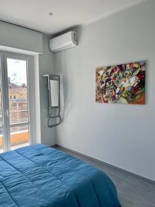 Un dormitorio con una cama azul y una pintura en la pared en Testa tra le Nuvole en Novi Ligure
