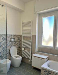 een badkamer met een toilet, een wastafel en een raam bij Testa tra le Nuvole in Novi Ligure
