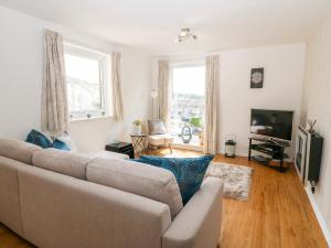 a living room with a couch and a television at Sea Breeze in Y Felinheli