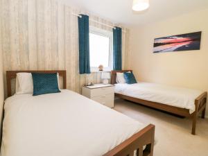 a bedroom with two beds and a window at Sea Breeze in Y Felinheli