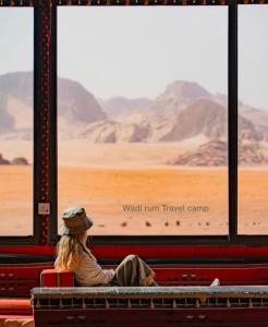 a woman sitting on a bench watching the desert from a train at Wadi Rum Travel camp in Wadi Rum