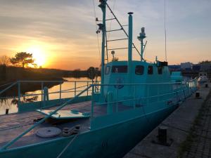 un bateau est amarré sur un quai au coucher du soleil. dans l'établissement Nebuchadnezzar, à Salacgrīva