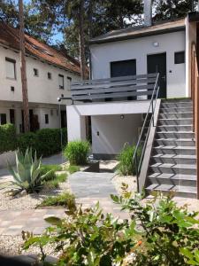 a house with a staircase in front of it at Tűlevél Apartman in Siófok +5 photos