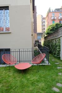 dwa czerwone stoły siedzące na trawie na podwórku w obiekcie La Maison City Life Apartments w Mediolanie