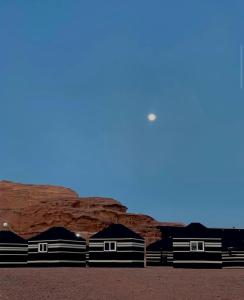 a group of buildings in front of a rock formation at Wadi Rum Travel camp in Wadi Rum