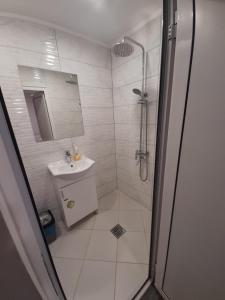 a white bathroom with a shower and a sink at Apartment Cozy Home 3 in Ruse
