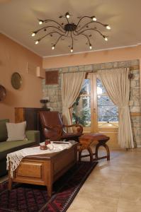 a living room with a bed and a couch and a chandelier at Roes Suites in Kato Loutraki