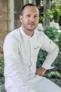 a man in a white chef outfit sitting down at Château de Fonscolombe - Relais & Châteaux in Le Puy-Sainte-Réparade