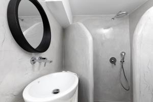 uma casa de banho com um lavatório, um espelho e um WC. em White Element em Karterados
