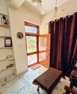 Zimmer mit einem Fenster und einer Bank vor einer Tür in der Unterkunft The Nest in Jaipur