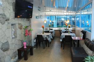 a restaurant with tables and chairs and a stone wall at Suna Bacata in Bogotá