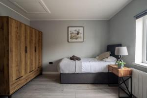 - une chambre avec un lit et une armoire en bois dans l'établissement Gorgeous House with BBQ Patio, à Great Yarmouth