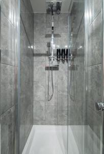 La salle de bains est pourvue d'une douche avec une porte en verre. dans l'établissement Gorgeous House with BBQ Patio, à Great Yarmouth